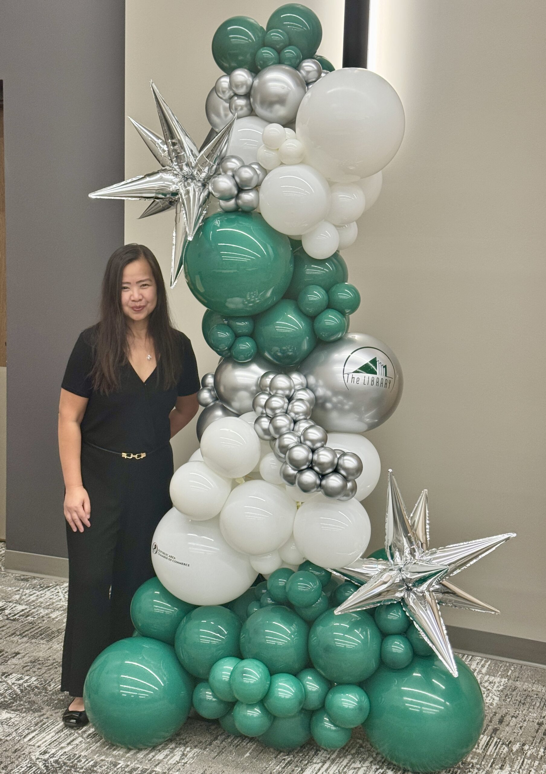 Simply Happy Balloons by Len owner standing beside a custom balloon display